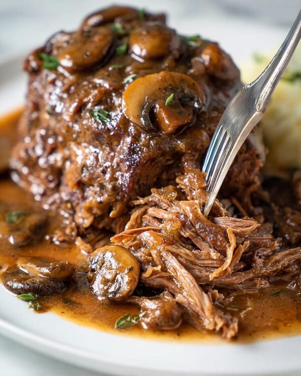 The image shows a white plate with two large pieces of brown cooked meat covered in a thick, shiny brown sauce with visible chunks of mushrooms mixed throughout. The sauce has a glossy texture and pools around the meat on the plate. Small whole mushrooms sit around the base of the meat, also coated in sauce. A woman's hand holding a silver fork is pulling apart the meat, showing its soft, shredded texture. The plate rests on a white marbled surface. Photo taken with an iphone --ar 4:5 --v 7