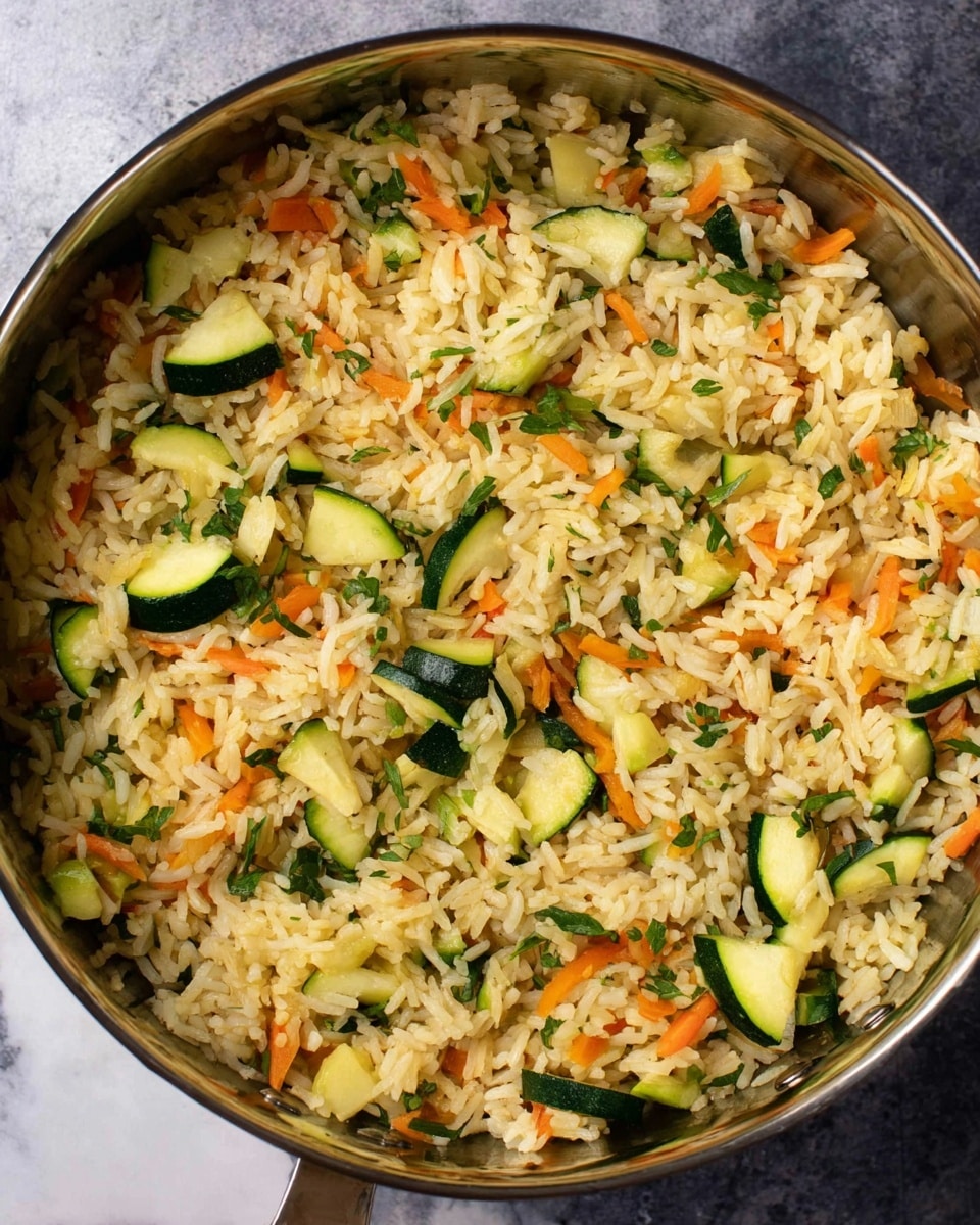 The image shows a pan filled with cooked rice mixed with sliced green zucchini, thin orange carrot strips, and green herbs. The rice grains are light golden and fluffy, scattered evenly with the vegetables. The zucchini pieces are cut into small half-moon shapes and are bright green with pale interiors, while the carrots add bright orange color throughout. The green herbs are finely chopped and sprinkled evenly, adding a fresh look. The pan is metallic and shiny, resting on a white marbled texture surface. Photo taken with an iphone --ar 4:5 --v 7