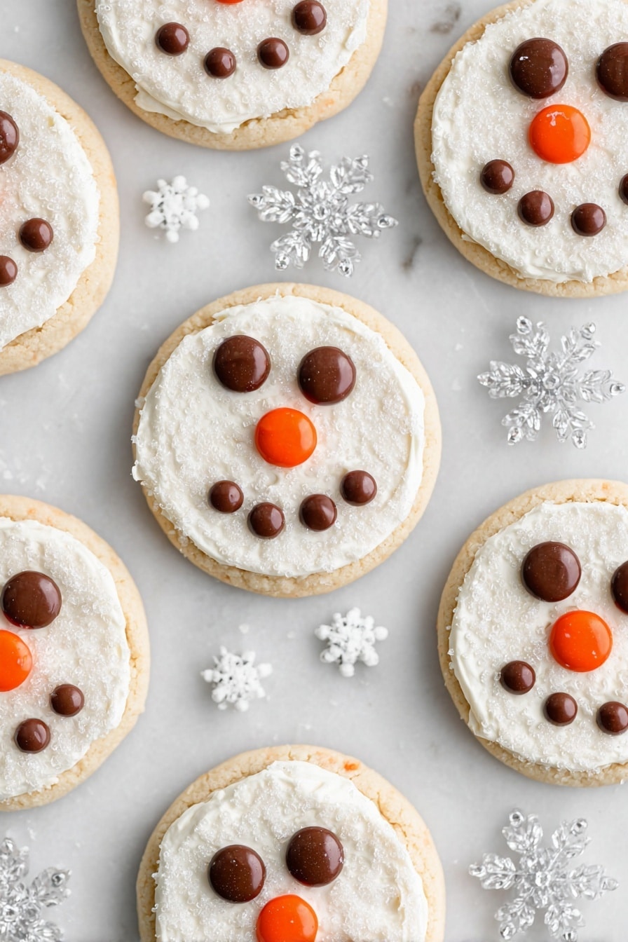 Snowman Face Cookies, Christmas cookies, holiday cookie ideas, winter baking recipes, easy decorated cookies - Several round cookies are arranged on a white marbled surface, each having two layers: a light golden cookie base and a thick, even layer of white frosting with a sugar crystal texture on top. On every cookie, chocolate candies form two eyes and a smiling mouth shape, while an orange candy is placed at the center to represent a nose. Clear plastic snowflake decorations and tiny white snowflake sprinkles are scattered around the cookies, enhancing the wintry theme. photo taken with an iphone --ar 2:3 --v 7
