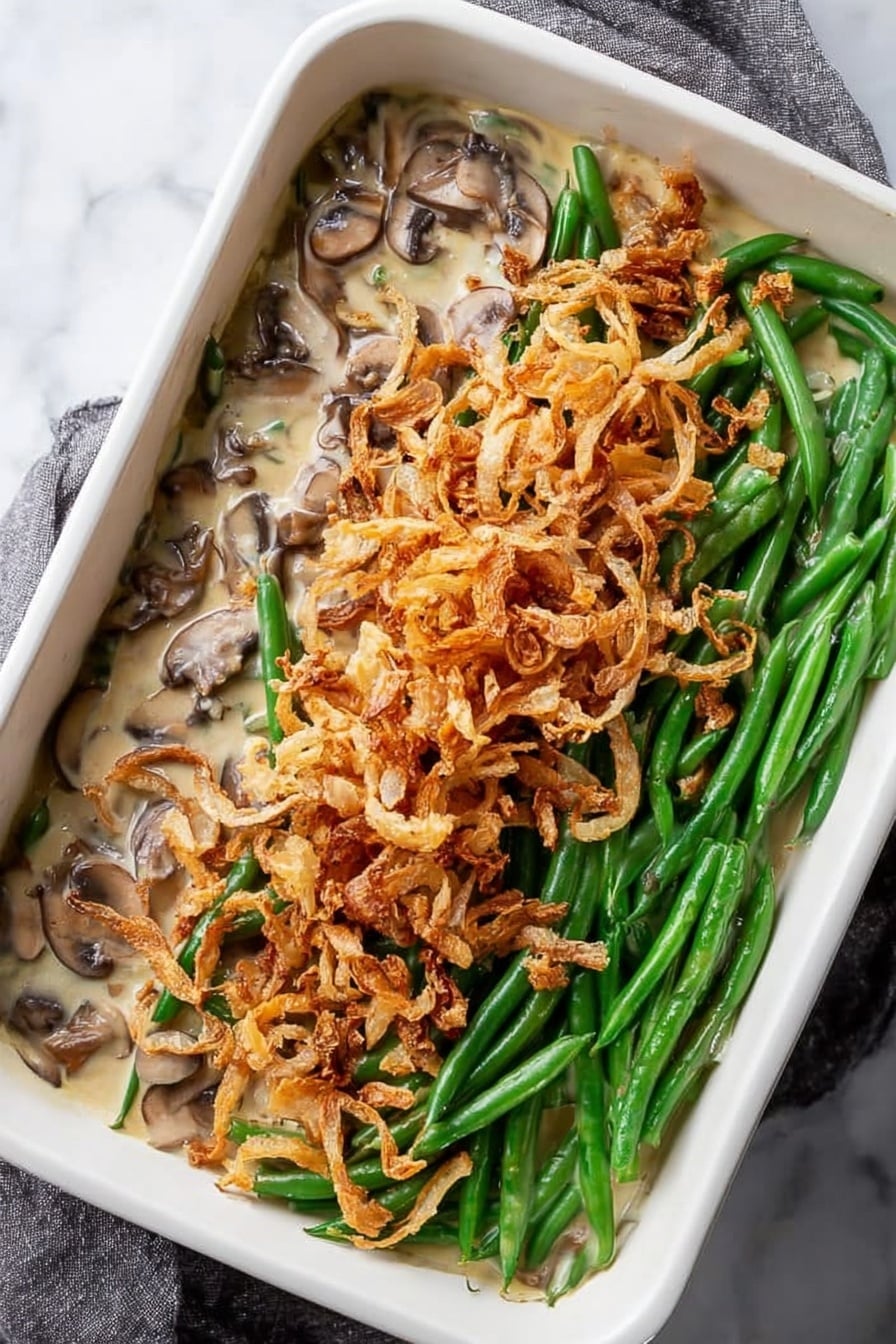 Green Bean Casserole with Mushroom Bechamel and Crispy Onion Topping, green bean casserole, mushroom bechamel sauce, crispy onion topping, classic side dish - A white square tray filled with a single thin layer of crispy fried onion strings, showing a mix of pale golden and light brown colors, some pieces are curled and others are straight, with slight dark brown edges indicating toasted spots. The texture looks crunchy and scattered unevenly across the tray, resting on a white marbled surface. Photo taken with an iphone --ar 2:3 --v 7