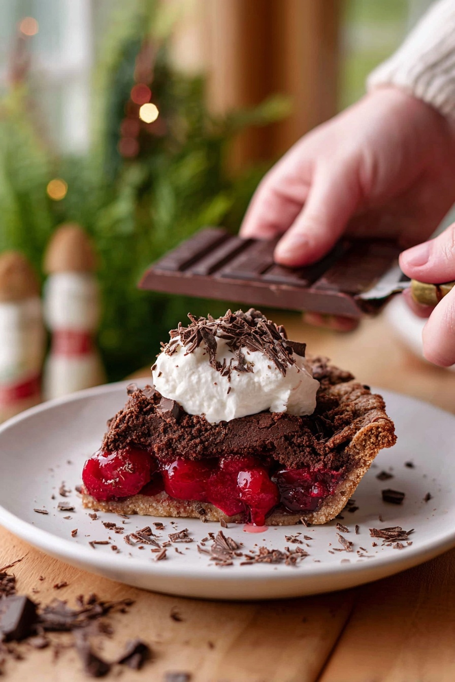 Chocolate Cherry Black Forest Pie, Chocolate Cherry Pie, Black Forest Pie Recipe, Cherry Chocolate Dessert, Easy Black Forest Pie - A slice of dark brown chocolate pie with a rough textured top layer sits on a white plate, revealing a thick, bright red cherry filling in the middle layer. On top of the pie slice, there is a dollop of white cream with small dark chocolate shavings scattered over it and around the plate. In the background, a woman’s hand is holding a dark chocolate bar and scraping chocolate shavings. The scene is set on a wooden surface with a soft focus of green plants and warm-toned decor in the background, all on a white marbled texture. photo taken with an iphone --ar 2:3 --v 7