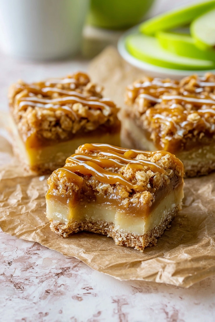 Salted Caramel Apple Pie Bars, apple pie bars with salted caramel, fall-inspired dessert recipes, easy apple dessert bars, caramel apple crumble bars - The image shows three square pieces of dessert bars on a crumpled piece of brown parchment paper resting on a white marbled surface. Each bar has three clear layers: a pale beige bottom layer that looks firm and smooth, a middle layer of light caramel filling, and a thick crumbly top layer coated with a shiny golden caramel drizzle. The crumbly top is textured with small oat pieces, giving a crunchy look. The bars are close together, with one piece having a bite taken out, showing the inside texture clearly. In the background, blurred green apple slices and a white cup are visible. Photo taken with an iphone --ar 2:3 --v 7