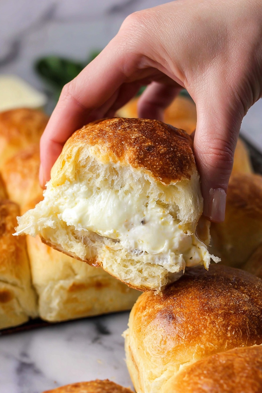 Cheesy Garlic Butter Pull Apart Rolls, cheesy garlic bread, pull apart bread, soft cheesy rolls, garlic butter bread - A woman's hand is pulling apart a soft bread roll that is golden brown on top with a slightly crispy crust. Inside, there is one thick, melted white cheese layer with a creamy texture visible in the center. The background shows more bread rolls that are golden on top, all placed on a white marbled surface. The photo taken with an iphone --ar 2:3 --v 7