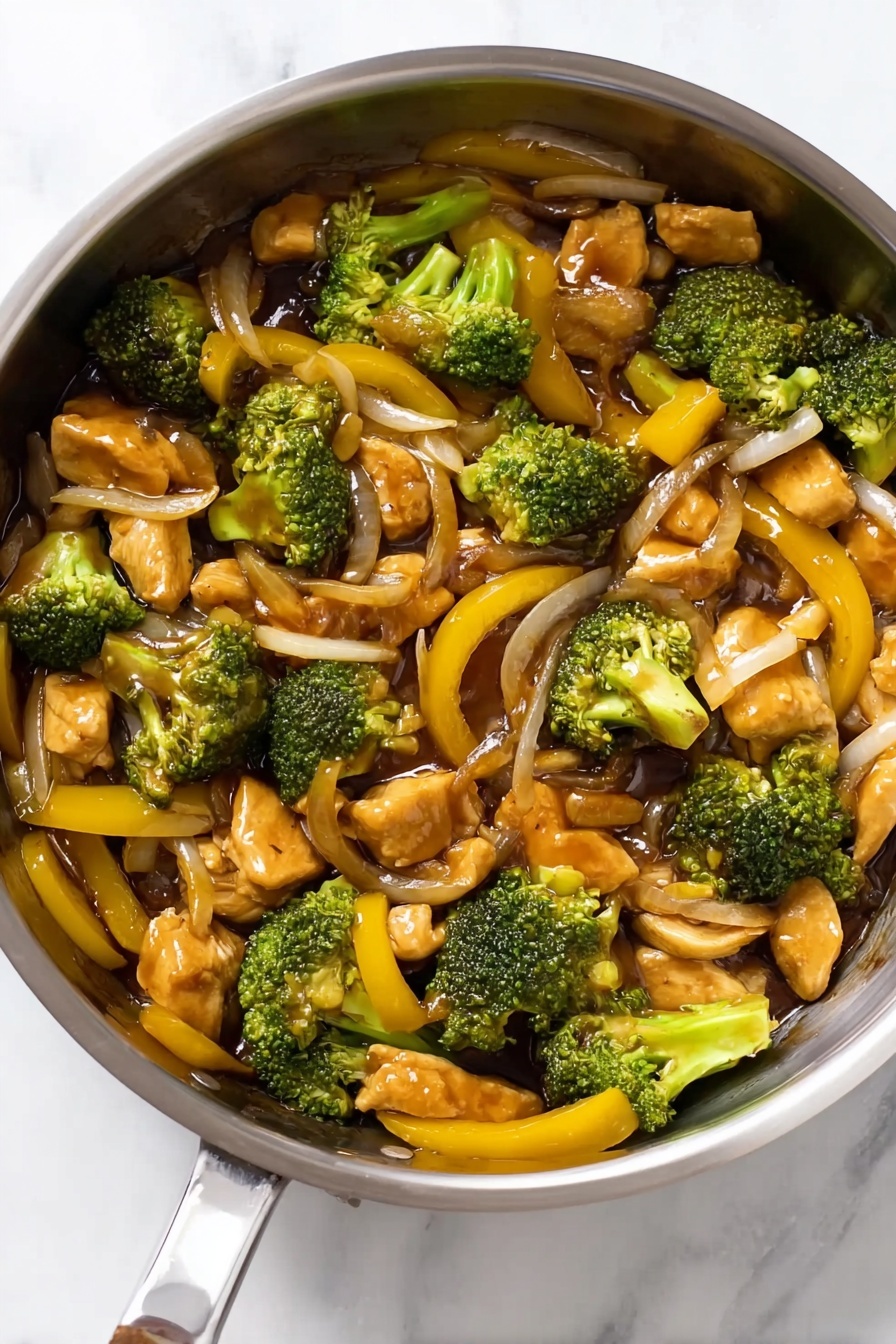 Chicken Broccoli Stir Fry, healthy chicken broccoli stir fry, quick stir fry recipes, easy Asian chicken dish, flavorful chicken broccoli dinner - The image shows a shiny stainless steel pan filled with a colorful stir-fry dish. The dish has several layers of ingredients: bright green broccoli pieces with a rough texture, soft-looking chunks of light brown chicken, thin yellow bell pepper strips with a smooth surface, and slices of translucent onion. The ingredients are mixed evenly, with a glossy brown sauce coating them, giving a slightly wet and shiny look. The pan is placed on a surface with a white marbled texture. photo taken with an iphone --ar 2:3 --v 7