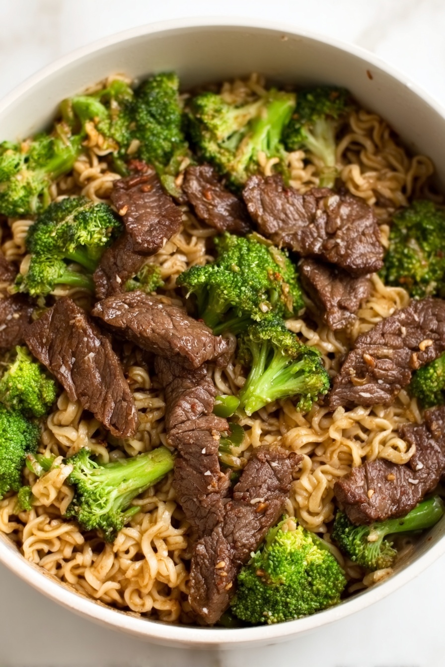 Beef Broccoli Ramen Stir Fry, Easy Beef Ramen Stir Fry, Quick Ramen Stir Fry Recipe, Healthy Beef and Broccoli Noodle Dish, Savory Ramen Stir Fry - A white bowl filled with a noodle dish topped with several pieces of dark brown cooked meat arranged evenly across the surface, mixed with bright green broccoli florets scattered throughout. The noodles underneath are light brown and slightly wavy, filling the entire bowl, with the meat and broccoli sitting on top. The glossy texture of the meat contrasts with the softer noodles and the fresh look of the broccoli, all placed on a white marbled surface. Photo taken with an iphone --ar 2:3 --v 7