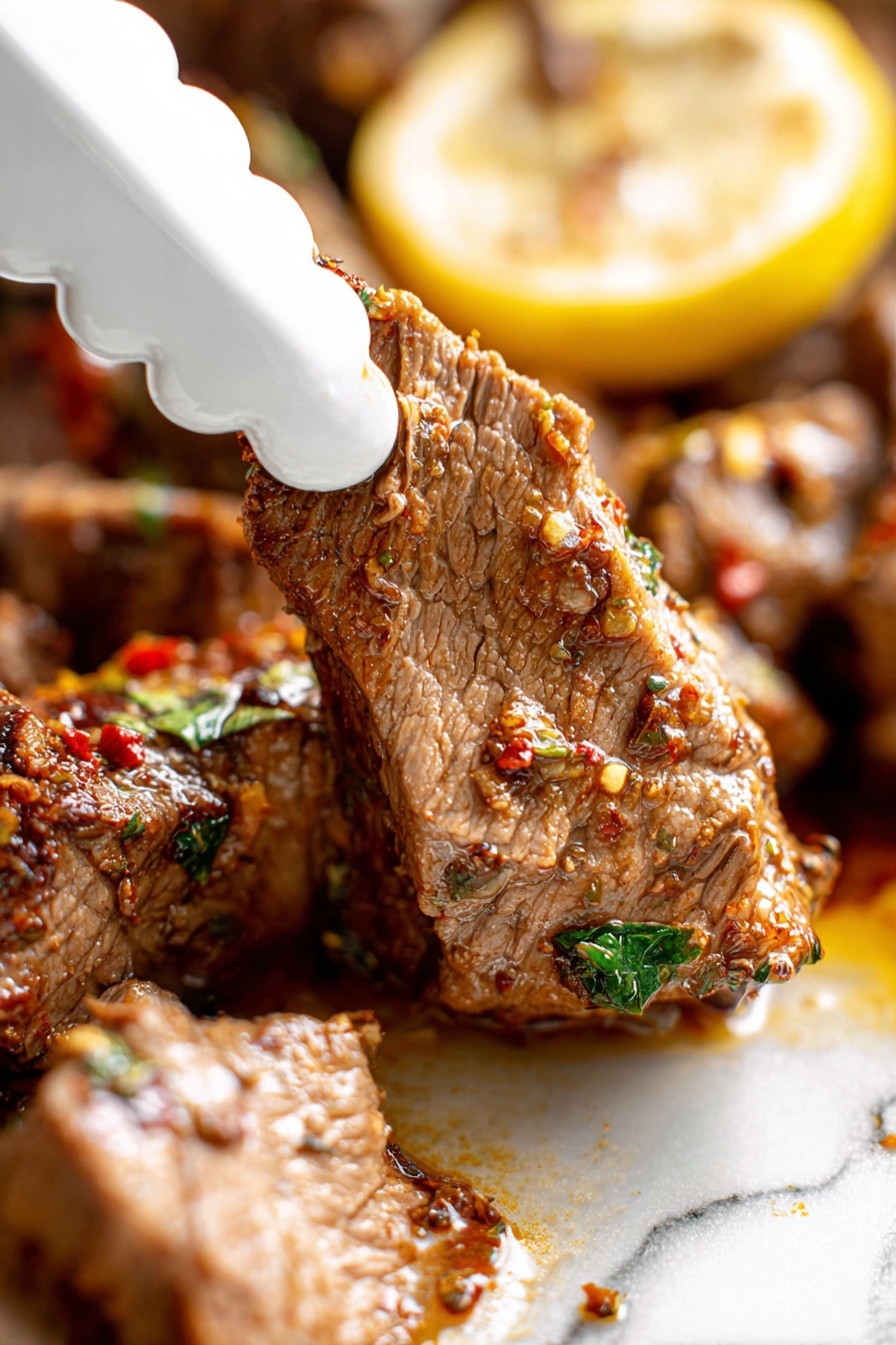 Slow Roasted Lamb Shoulder with Mint Sauce, Lamb shoulder recipe, slow roast lamb, mint sauce for lamb, tender lamb roast - A close-up view of a piece of cooked meat being picked up by a white scalloped-edge tong, showing its tender texture with visible fibers and seasoning bits in red and green. The meat is brown with a moist surface, sitting next to a larger piece with the same texture, all on a white marbled surface. Behind the meat, there is a yellow lemon slice with some herbs on top, adding a pop of color. The scene is bright and focused on the meat’s juicy and spiced detail, photo taken with an iphone --ar 2:3 --v 7