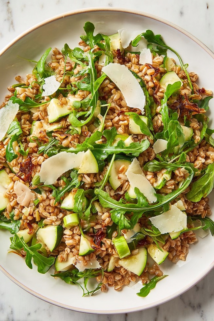 Ultimate Farro Salad with Apple and Basil, healthy farro salad with apple and basil, easy farro salad recipe with apple and basil, flavorful farro salad with fruit, nutritious brunch salad with farro - A clear glass bowl holds a mixed salad with three main layers: a bottom layer of cooked brown grains, a middle layer of bright green arugula leaves with thin stems, and a top layer scattered with thin white cheese shavings and small green apple pieces. The grains look slightly shiny, and the arugula adds a fresh, leafy texture. The bowl sits on a white marbled surface with two empty white bowls in the background. Photo taken with an iphone --ar 2:3 --v 7
