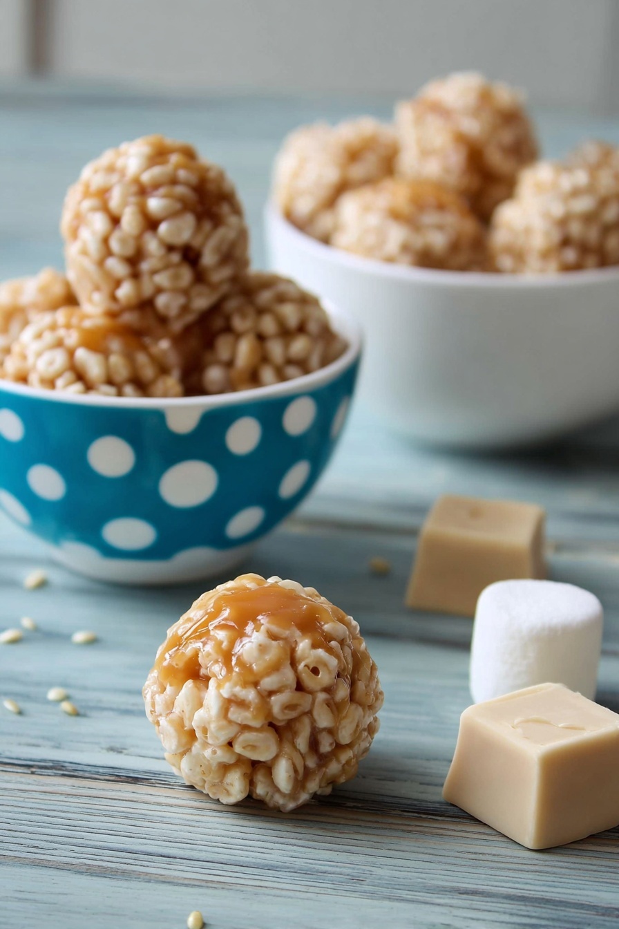 Marshmallow Caramel Rice Krispies Puffs, marshmallow caramel rice krispie treats, easy caramel rice krispie snack, homemade rice krispies with caramel, chewy caramel rice krispie bars - The image shows small round treats with a light caramel center covered in a layer of puffed rice. There are three of these treats inside a white bowl with blue and white polka dots on the left side of the image, and a white bowl filled with more treats is in the background on a white marbled surface. Two caramel squares and a large white marshmallow are placed behind one treat in the middle foreground, and a single treat sits on the white marbled surface near the front. The treat's outer puffed rice layer is beige and textured, while the caramel inside is shiny and smooth. photo taken with an iphone --ar 2:3 --v 7