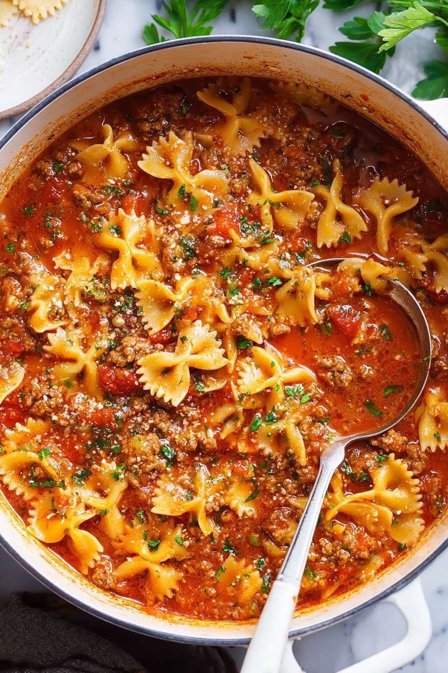 Lasagna Soup, Easy Lasagna Soup, Quick Lasagna Soup, Cheesy Lasagna Soup, Comforting Soup Recipes - A large white pot filled with a thick stew made of bowtie pasta, ground meat, and rich red tomato sauce, garnished with small bits of green herbs on top; the sauce has a shiny, slightly oily surface with tomatoes and herbs visible throughout. A silver ladle with a white handle rests inside the pot, partially submerged in the stew. The background shows a white marbled surface with some green leaves and a white round dish partially visible on the side. photo taken with an iphone --ar 2:3 --v 7