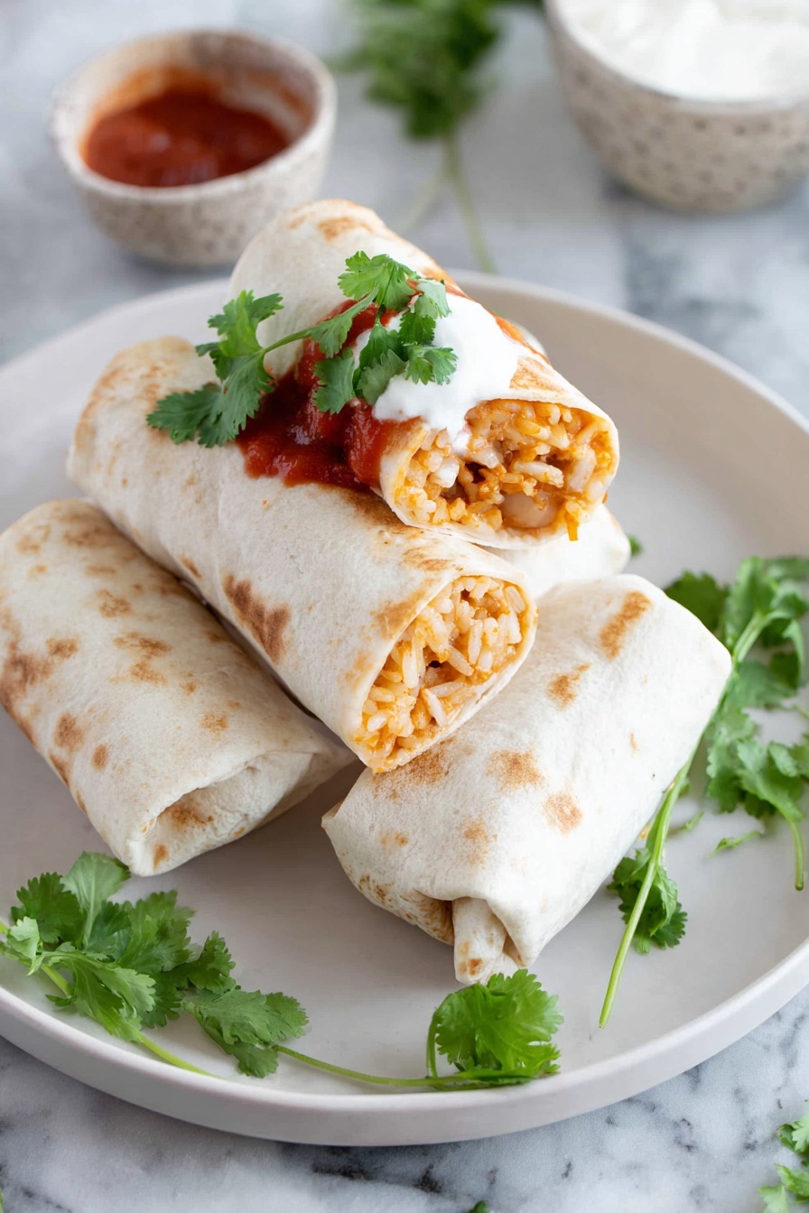 Cheesy Bean and Rice Burritos, Mexican-style burritos, cheesy bean wrap, baked bean and rice burritos, hearty vegetarian burritos - Two soft white tortillas are rolled and placed on a white plate, one whole and one cut in half showing a mix of orange-brown rice and beans inside. The cut burrito is stacked on top of the whole one. A dollop of white sour cream and red salsa sauce with some fresh green cilantro leaves are on top of the burritos. Extra cilantro leaves are scattered on the plate around the burritos. In the background, there is a small bowl of white sour cream on the white marbled surface. The photo is taken with an iphone --ar 2:3 --v 7