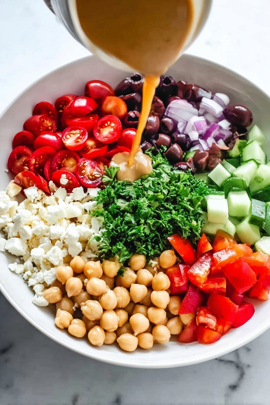 Mediterranean Chickpea Salad, healthy Mediterranean salad, quick vegetarian meals, easy chickpea salad, colorful veggie salad - A white bowl holds seven distinct layers arranged in a circle on a white marbled surface. Starting from the left, there are bright red, halved cherry tomatoes, next to a pile of small, crumbly white cheese pieces. Moving clockwise, a section of dark purple sliced olives sits beside chopped fresh green parsley in the center. Next to the parsley are cubes of light green cucumber and bright red diced bell peppers. Opposite the tomatoes, tan chickpeas form a rounded cluster. A woman's hand pours a smooth, light brown dressing from a jar over the ingredients, adding a glossy shine to the mix. photo taken with an iphone --ar 2:3 --v 7