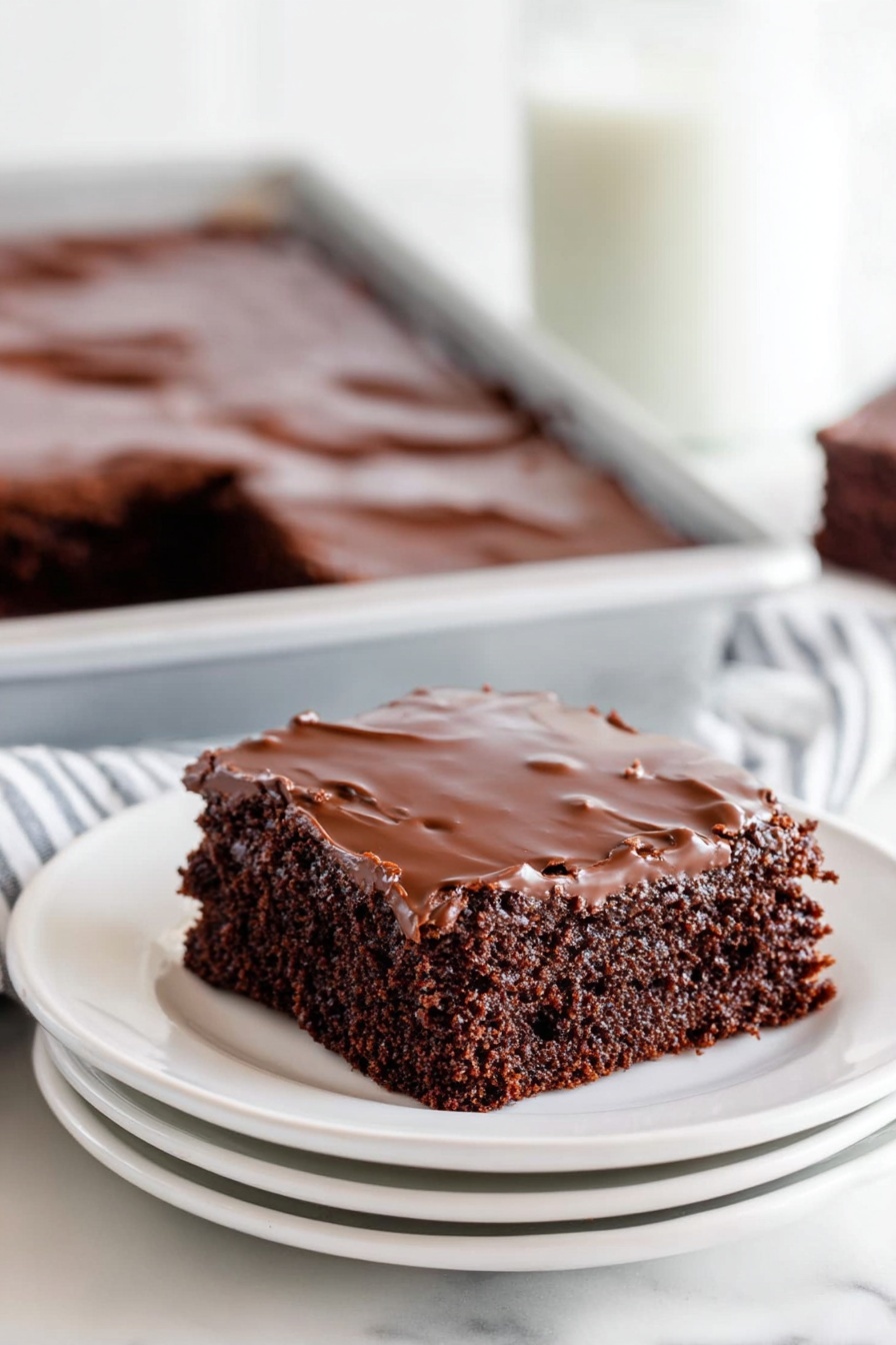 Texas Sheet Cake with Chocolate Frosting, Southern chocolate cake recipe, easy chocolate sheet cake, moist chocolate cake, chocolate dessert for sharing - A close-up of a chocolate sheet cake with two layers, the bottom layer is a soft, dark brown cake with a slightly crumbly texture, and the top layer is a shiny, smooth chocolate glaze covering the entire surface. The cake is cut into squares, and one piece is missing, revealing the inside texture. The cake is inside a white baking pan set on a white marbled surface, with parts of a woman's hand visible holding the pan. In the background, there is a soft blur of stacked white plates. photo taken with an iphone --ar 2:3 --v 7
