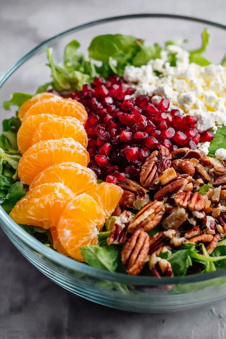Winter Citrus Salad with Pomegranate and Feta, citrus salad recipe, healthy winter salad, holiday citrus salad, easy citrus and feta salad - A clear glass bowl holding a fresh salad on a white marbled surface, with a base layer of mixed green leaves. On one side are bright orange segments of peeled mandarins, stacked together. Next to the mandarins, crumbled white cheese is placed, adding a soft texture. Beside the cheese, there is a pile of small, glossy red pomegranate seeds. On the last side, a heap of chopped brown pecans adds a crunchy contrast. Photo taken with an iphone --ar 2:3 --v 7