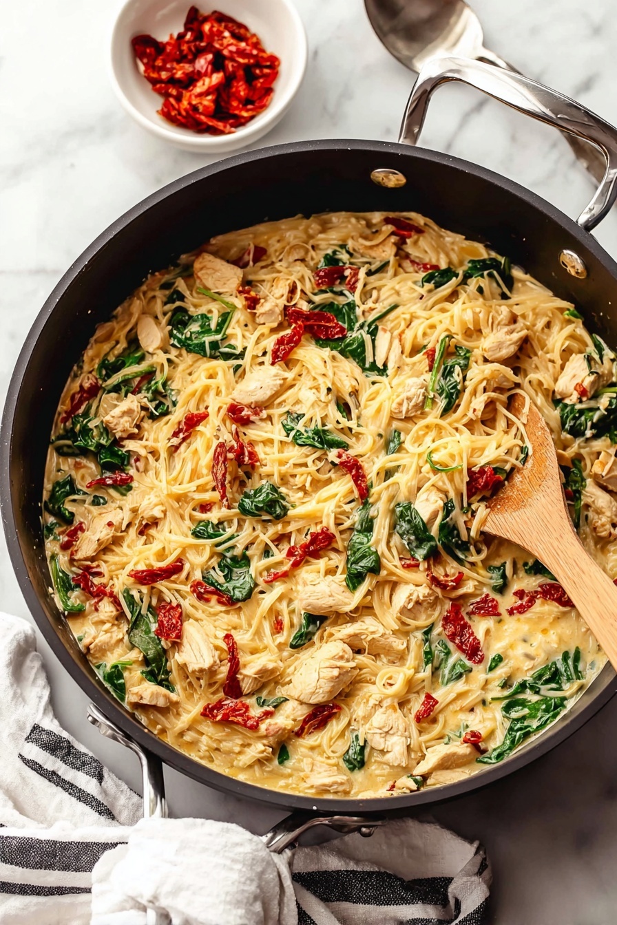 Tuscan Chicken Spaghetti Squash, healthy chicken spaghetti squash, creamy chicken squash skillet, easy Tuscan chicken recipe, low-carb spaghetti squash dishes - A large black pan filled with a creamy pasta dish that has three main layers: the creamy sauce with melted cheese forms the base, mixed through with tender pieces of seasoned light brown chicken, bright green spinach leaves, and small chunks of red sun-dried tomatoes scattered evenly throughout. A light wooden spoon is stirring the mixture from the right side of the pan. Near the pan, on a white marbled surface, sits a small white bowl filled with more red sun-dried tomatoes and a silver spoon nearby. A white cloth with black stripes is placed casually under the pan handle. Photo taken with an iphone --ar 2:3 --v 7
