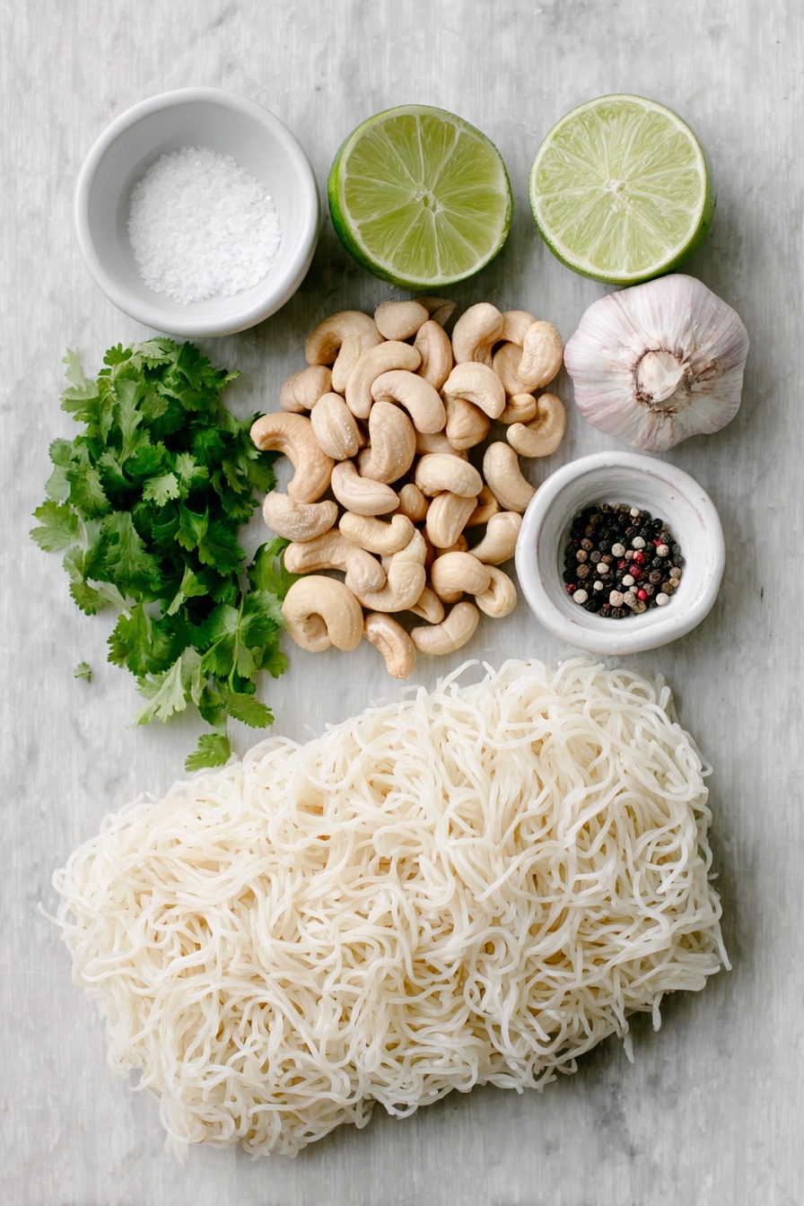 Vegan Cilantro Lime Noodles, vegan noodle recipes, healthy pasta dishes, quick plant-based meals, flavorful vegan noodle ideas - Flat lay of raw cashews in a small pile, a small handful of bright green cilantro sprigs, two whole uncracked garlic cloves, a whole fresh lime with one half cut to show the juicy interior and scattered lime zest, a small white ceramic bowl filled with clear water, a small white ceramic bowl containing coarse salt, a small white ceramic bowl with cracked black peppercorns, and a neat bundle of tofu shirataki spaghetti shaped noodles, all arranged in perfect symmetry on a clean white marble surface, soft natural light, photo taken with an iPhone, professional food photography style, fresh ingredients, white ceramic bowls, no bottles, no duplicates, no utensils, no packaging --ar 2:3 --v 7 --p m7354615311229779997