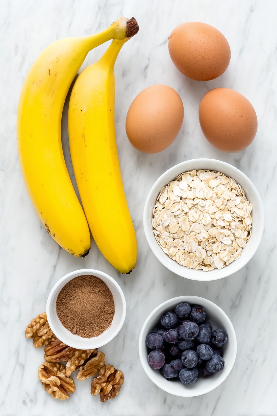 Healthy Banana Oatmeal Pancakes, best banana oatmeal pancakes, easy nutritious pancake recipe, wholesome breakfast pancakes, fluffy banana oat pancakes - Flat lay of two ripe bananas with natural brown speckles, two whole uncracked brown eggs, a small white ceramic bowl filled with rolled oats, a small white bowl holding ground cinnamon powder, a few fresh blueberries scattered beside a small pile of walnut halves, all arranged symmetrically and balanced, placed on a clean white marble surface, soft natural light, photo taken with an iPhone, professional food photography style, fresh ingredients, white ceramic bowls, no bottles, no duplicates, no utensils, no packaging --ar 2:3 --v 7 --p m7354615311229779997